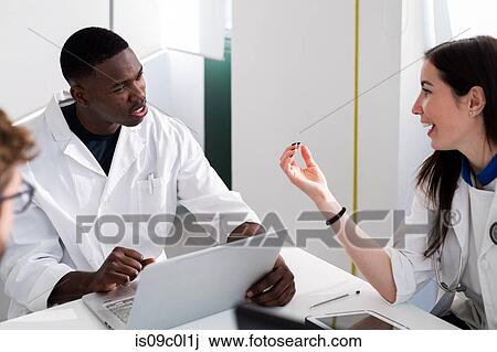 Stock Image - Doctors having discussion in meeting room. Fotosearch