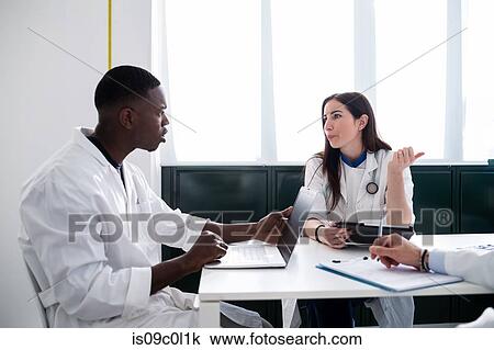 Stock Image - Doctors having discussion in meeting room. Fotosearch