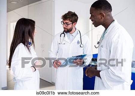Doctors talking at hospital reception View Large Photo Image Stock Image - Doctors talking at hospital reception. Fotosearch