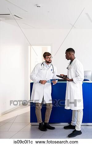 Doctors talking at hospital reception View Large Photo Image Stock Image - Doctors talking at hospital reception. Fotosearch
