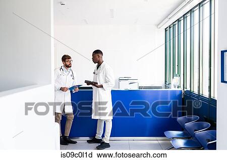 Doctors talking at hospital reception View Large Photo Image Stock Image - Doctors talking at hospital reception. Fotosearch