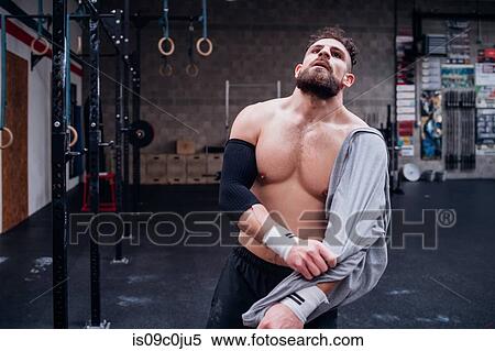 Exhausted young man taking break in gym View Large Photo Image Stock Photography - Exhausted young man taking break in gym. Fotosearch
