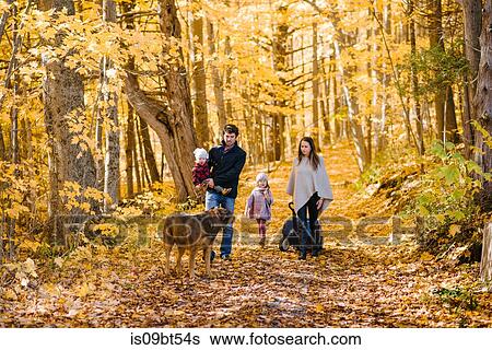Stock Photograph - Family of four and dog in forest. Fotosearch