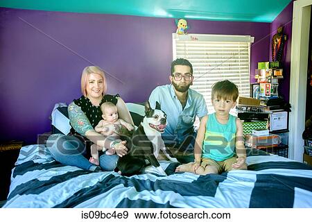 Stock Photo - Family on bed in bedroom. Fotosearch