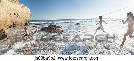 Stock Image - Family playing on El Matador Beach, Malibu, USA. Fotosearch