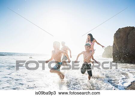 Stock Image - Family playing on El Matador Beach, Malibu, USA. Fotosearch