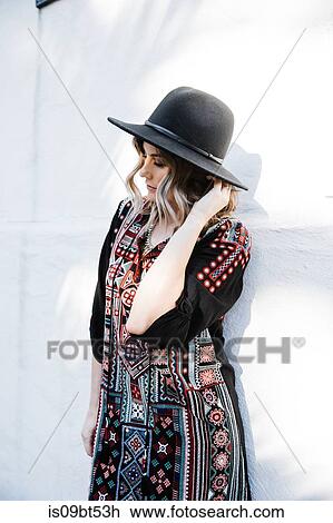 Fashionable woman posing against white wall View Large Photo Image Stock Image - Fashionable woman posing against white wall. Fotosearch