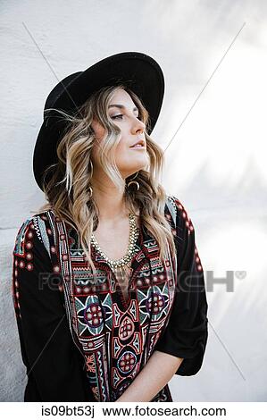 Fashionable woman posing against white wall View Large Photo Image Stock Image - Fashionable woman posing against white wall. Fotosearch