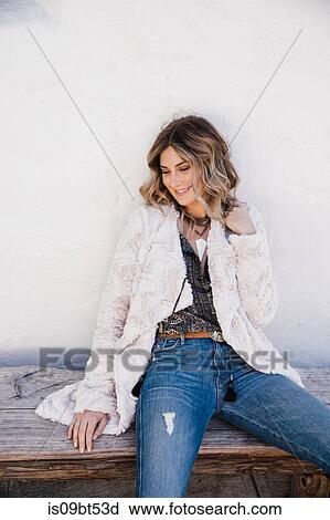 Fashionable woman sitting on wooden bench View Large Photo Image Stock Image - Fashionable woman sitting on wooden bench. Fotosearch