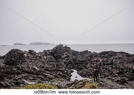 Father and child walking on rocks, Tofino, Canada View Large Photo Image Picture - Father and child walking on rocks, Tofino, Canada. Fotosearch