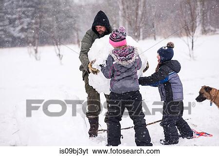 Father and children carrying large snowball View Large Photo Image Stock Photograph - Father and children carrying large snowball. Fotosearch