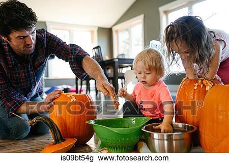 Father and children gutting pumpkin at home View Large Photo Image Stock Image - Father and children gutting pumpkin at home. Fotosearch