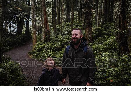 Stock Image - Father and daughter hiking in forest, Tofino, Canada. Fotosearch