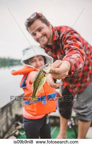Father and daughter in boat on lake, father showing daughter caught fish View Large Photo Image Stock Photo - Father and daughter in boat on lake, father showing daughter caught fish. Fotosearch