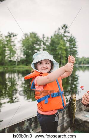 Father and daughter in boat on lake, daughter holding caught fish on line View Large Photo Image Stock Photo - Father and daughter in boat on lake, daughter holding caught fish on line. Fotosearch