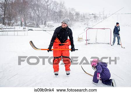 Father and daughter playing ice hockey in winter landscape View Large Photo Image Picture - Father and daughter playing ice hockey in winter landscape. Fotosearch