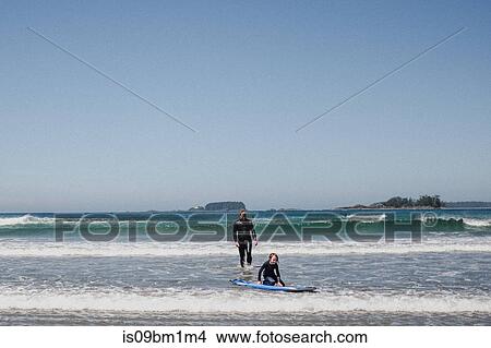 Father and daughter surfing on beach, Tofino, Canada View Large Photo Image Picture - Father and daughter surfing on beach, Tofino, Canada. Fotosearch