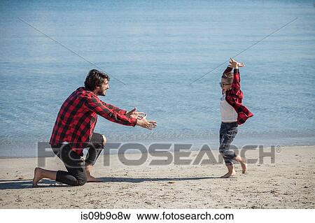 Father and son on beach, son running towards father View Large Photo Image Stock Photo - Father and son on beach, son running towards father. Fotosearch