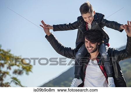 Father and son outdoors, father carrying son on shoulders View Large Photo Image Picture - Father and son outdoors, father carrying son on shoulders. Fotosearch