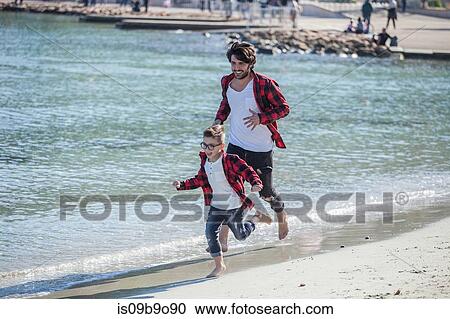 Father and son running along beach View Large Photo Image Stock Image - Father and son running along beach. Fotosearch