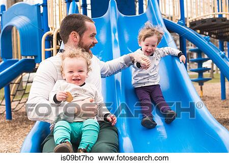 Father and sons playing on slide View Large Photo Image Picture - Father and sons playing on slide. Fotosearch