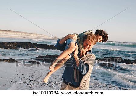 Father carrying son over shoulder on beach View Large Photo Image Picture - Father carrying son over shoulder on beach. Fotosearch