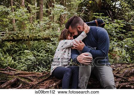 Stock Image - Father comforting daughter in forest, Tofino, Canada. Fotosearch