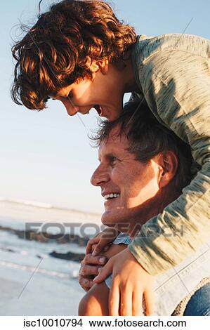 Father giving son piggyback ride on beach View Large Photo Image Picture - Father giving son piggyback ride on beach. Fotosearch