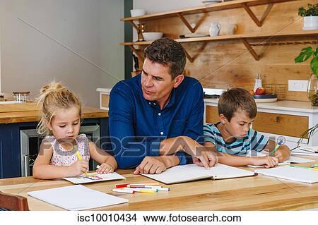 Father helping children with homework at home View Large Photo Image Picture - Father helping children with homework at home. Fotosearch