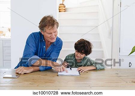 Father helping son with homework at home View Large Photo Image Stock Photo - Father helping son with homework at home. Fotosearch