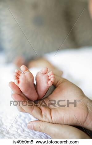 Father holding baby boy's feet, close-up View Large Photo Image Stock Photography - Father holding baby boy's feet, close-up. Fotosearch