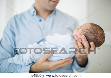 Father holding newborn baby boy, mid section View Large Photo Image Stock Photo - Father holding newborn baby boy, mid section. Fotosearch
