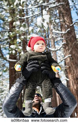 Father holding up baby son in winter forest, South Lake Tahoe, California, USA View Large Photo Image Stock Image - Father holding up baby son in winter forest, South Lake Tahoe, California, USA. Fotosearch
