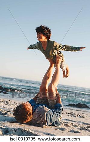 Father lifting son in mid air with legs on beach View Large Photo Image Stock Photography - Father lifting son in mid air with legs on beach. Fotosearch