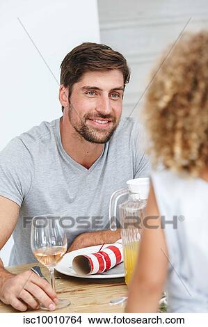 Picture - Father listening attentively to daughter at dining table. Fotosearch