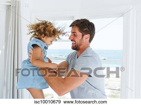 Father playing and swinging daughter in beach house View Large Photo Image Stock Photo - Father playing and swinging daughter in beach house. Fotosearch