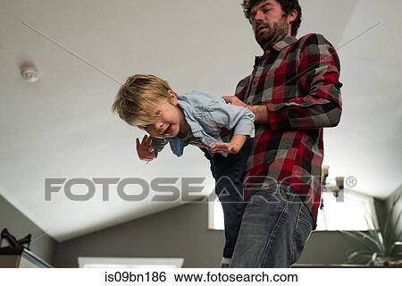 Stock Photograph - Father playing with son at home. Fotosearch