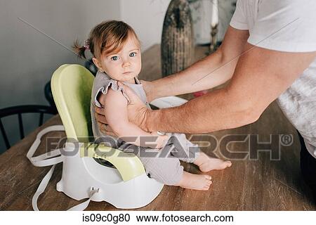 Father putting baby daughter in child seat, cropped portrait View Large Photo Image Stock Image - Father putting baby daughter in child seat, cropped portrait. Fotosearch