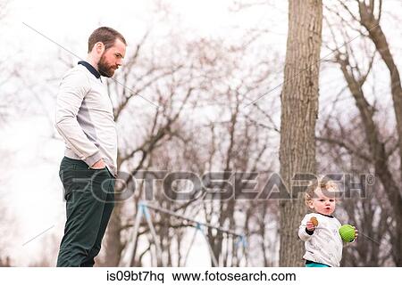 Stock Photography - Father watching over son in park. Fotosearch
