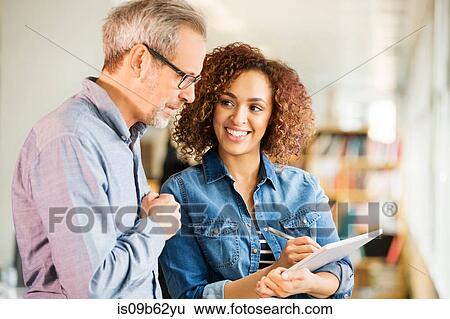 Female and male digital designers making notes in office View Large Photo Image Stock Photograph - Female and male digital designers making notes in office. Fotosearch