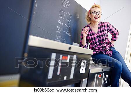 Female laundrette owner sitting on top of washing machine by chalkboard View Large Photo Image Stock Image - Female laundrette owner sitting on top of washing machine by chalkboard. Fotosearch