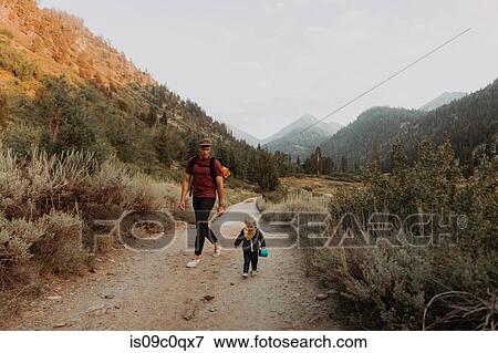 Stock Photo - Female toddler and young man walking along rural road, Mineral King, California, USA. Fotosearch