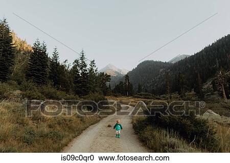 Stock Image - Female toddler toddling on rural valley road, Mineral King, California, USA. Fotosearch