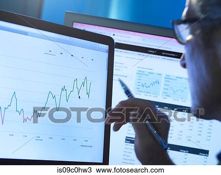 Stock Image - Financial services, stock analyst researching share price data of a company on the computer. Fotosearch