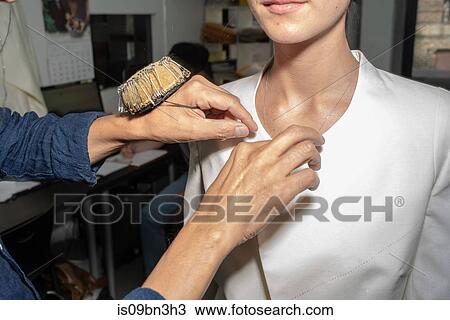 Stock Image - Fit model in fitting of tailored jackets before fashion week. Fotosearch