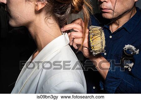 Stock Photo - Fit model in fitting of tailored jackets before fashion show. Fotosearch