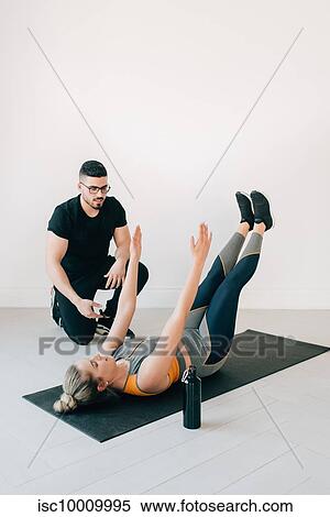 Fitness instructor observing woman doing core exercise in stu View Large Photo Image Stock Photography - Fitness instructor observing woman doing core exercise in stu. Fotosearch
