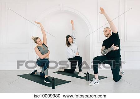 Fitness instructor teaching women stretching arm in studio View Large Photo Image Stock Image - Fitness instructor teaching women stretching arm in studio. Fotosearch