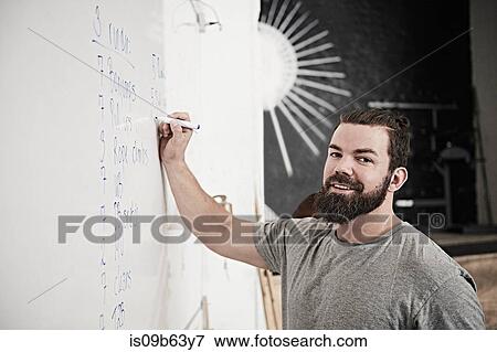 Fitness instructor writing on whiteboard in cross training gym View Large Photo Image Stock Photo - Fitness instructor writing on whiteboard in cross training gym. Fotosearch