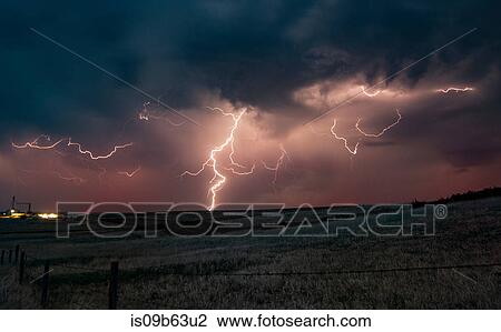 Stock Image - Forked lightning in orange sky over rural area, Grant, Nebraska, United States, North America. Fotosearch
